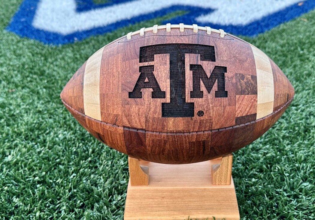 Handcrafted wooden football featuring the Texas A&M University logo, showcasing custom engravings.